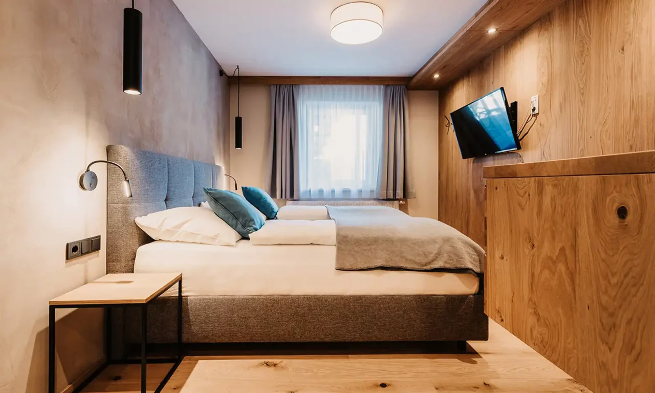 Modernes Schlafzimmer im Hofgut Wagrain – stilvolle Gemütlichkeit mit natürlichen Materialien, hochwertigem Bettkomfort und alpinem Flair.