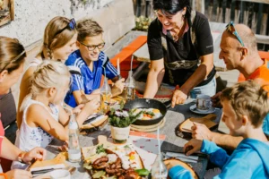 A cheerful family enjoying a savoury snack with fried eggs in a sunny mountain hut - genuine hospitality and regional delights in Salzburger Land.