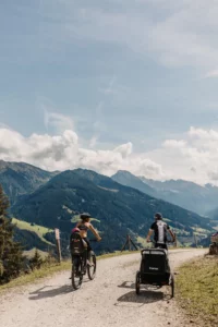 Family time on two wheels - e-bike tour with child seat and trailer along sunny panoramic routes in the Alps around Hofgut Wagrain.