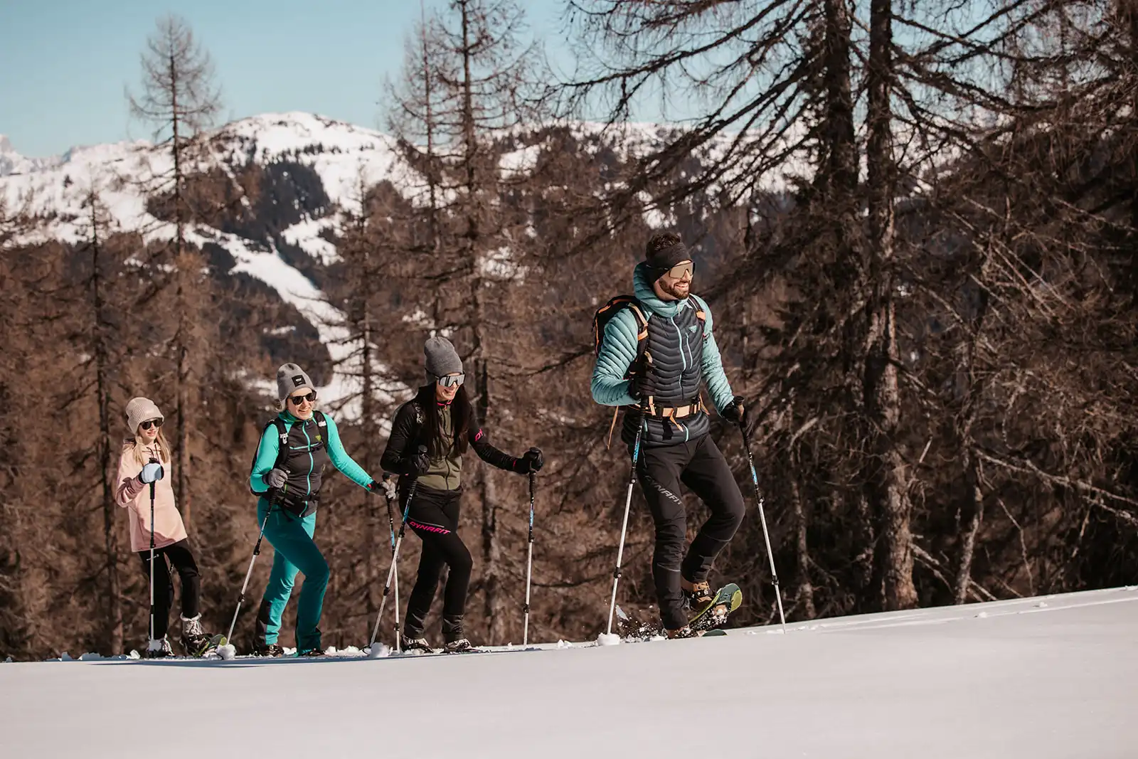Winterabenteuer für die ganze Familie – Schneeschuhwandern in der verschneiten Bergwelt rund um das Hofgut Wagrain, mit strahlendem Sonnenschein und Panoramablick auf die Alpen.