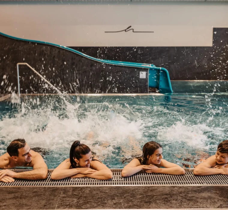 Carefree bathing fun for the whole family: In the warm indoor pool at Hofgut Wagrain, young and old can enjoy exuberant moments - with a water slide, splashing fun and lots of laughter.