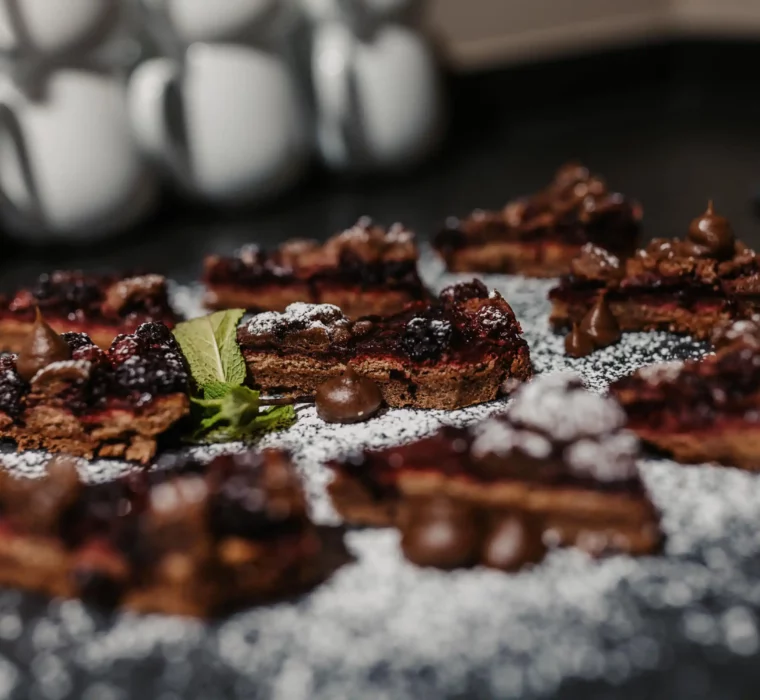 Hausgemachte Schokoküchlein mit Beeren und Minze – süße Verführung im Hofgut Wagrain, liebevoll angerichtet und mit Puderzucker verfeinert.