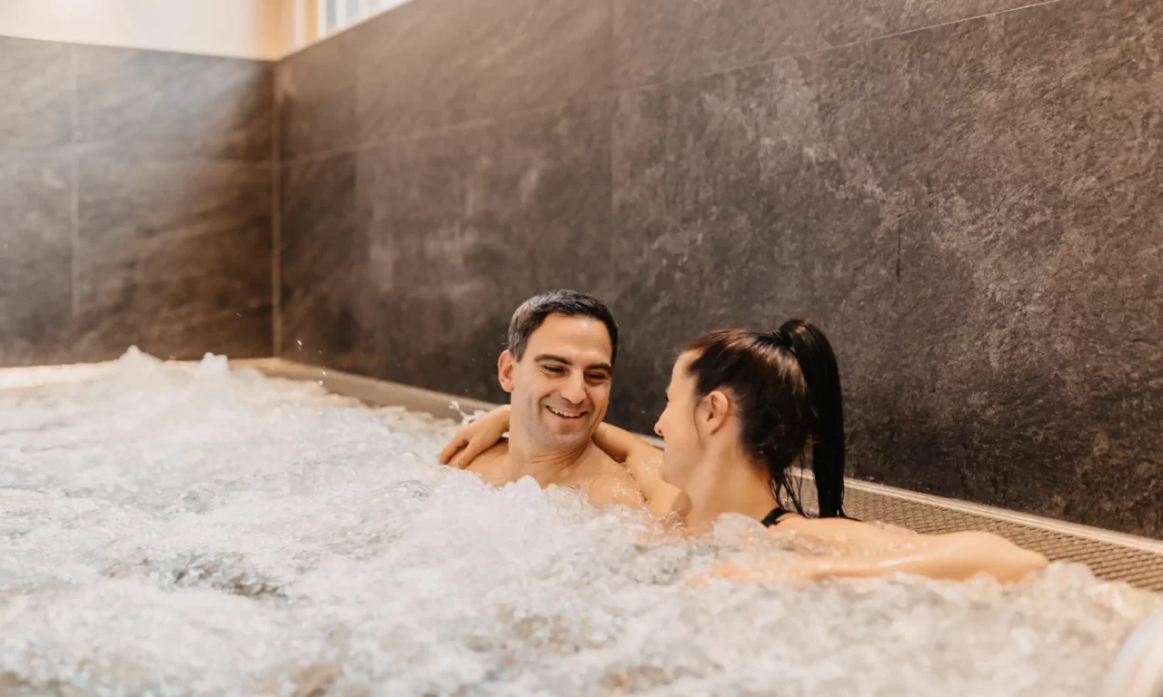 Wellness nur für Erwachsene im Hofgut Wagrain: Pärchen genießen entspannte Momente im Whirlpool.