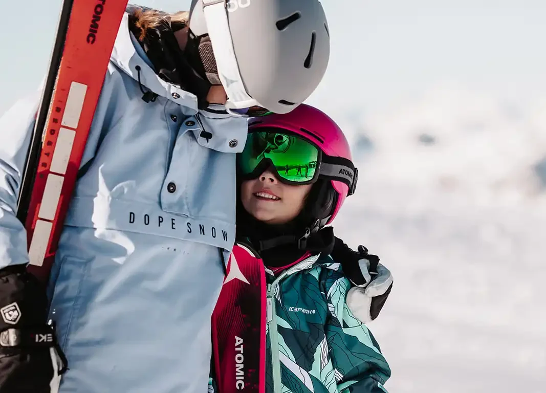 Kinder mit Skiern auf Schnee in den Bergen von Snow Space Salzburg.