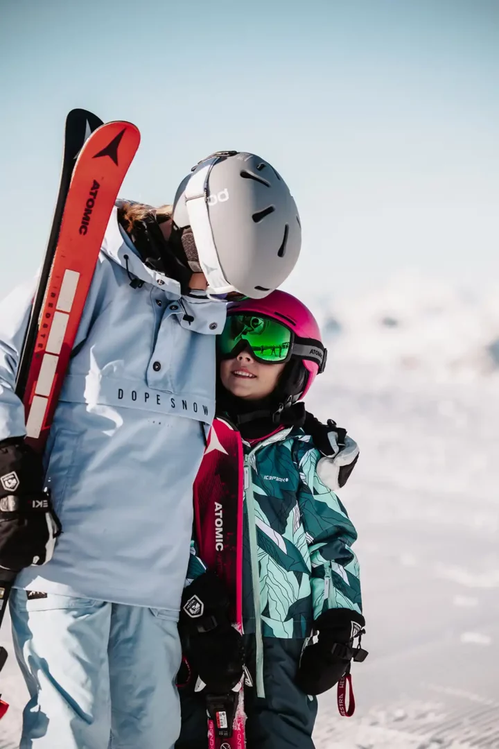 Kinder mit Skiern auf Schnee in den Bergen von Snow Space Salzburg.