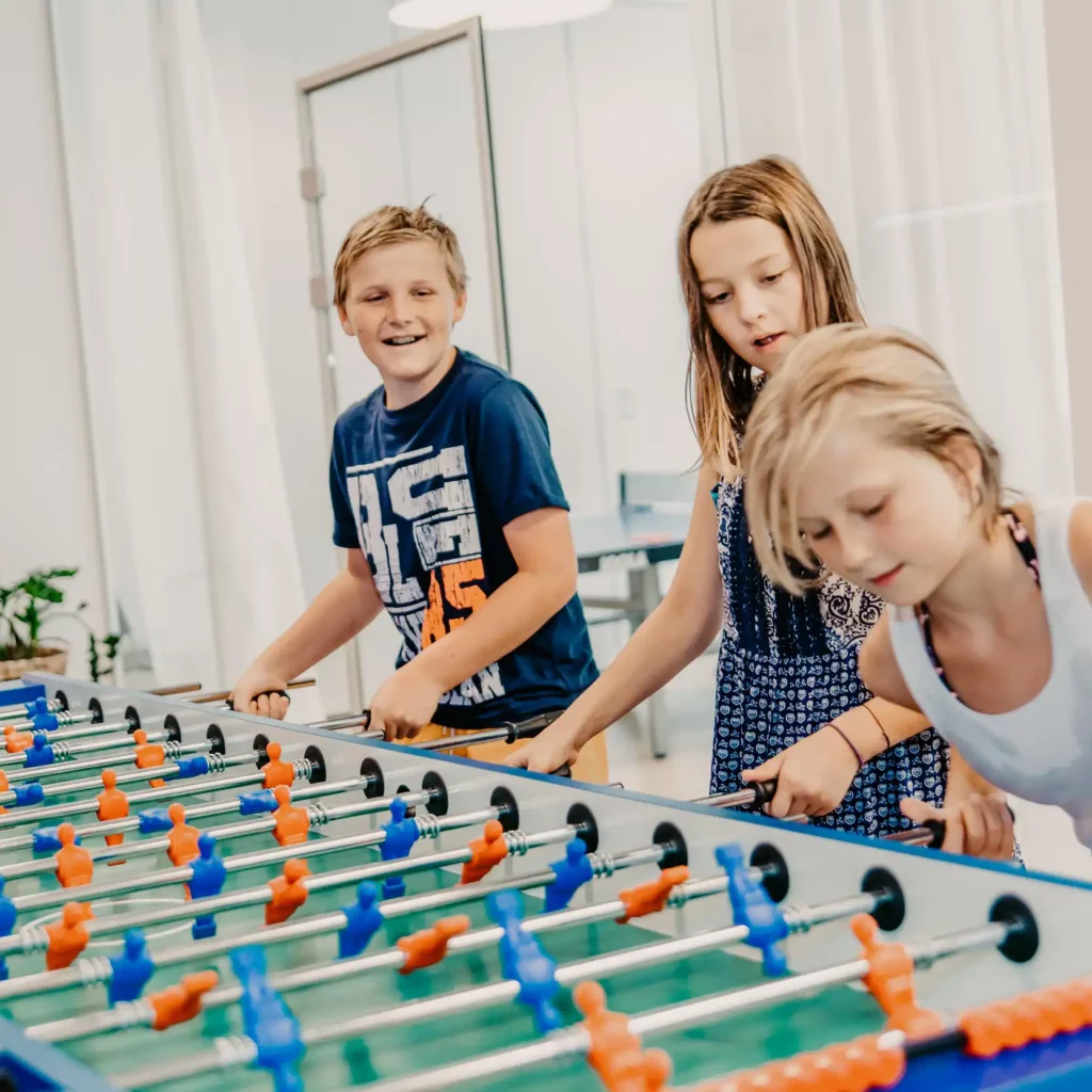 05.HOFGUT-apartment-lifestyle-resort-apartment-kicker-wuzzler Kinder spielen Tischfußball im Hofgut Wagrain.