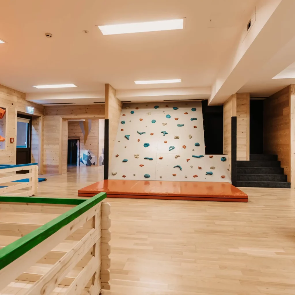 Hofgut-aparment-lifestyle-resort-wagrain-133 Kletterwand im Indoor-Spielbereich des Hofgut Wagrain – spielerisches Abenteuer und Bewegung für kleine Bergsteiger in sicherer Umgebung.