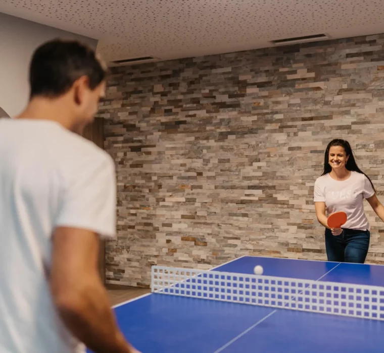 Sportlicher Spaß im Urlaub: Ein Tischtennis-Duell mit viel Lachen und Bewegung – Aktivzeit für Paare im Hofgut Wagrain.