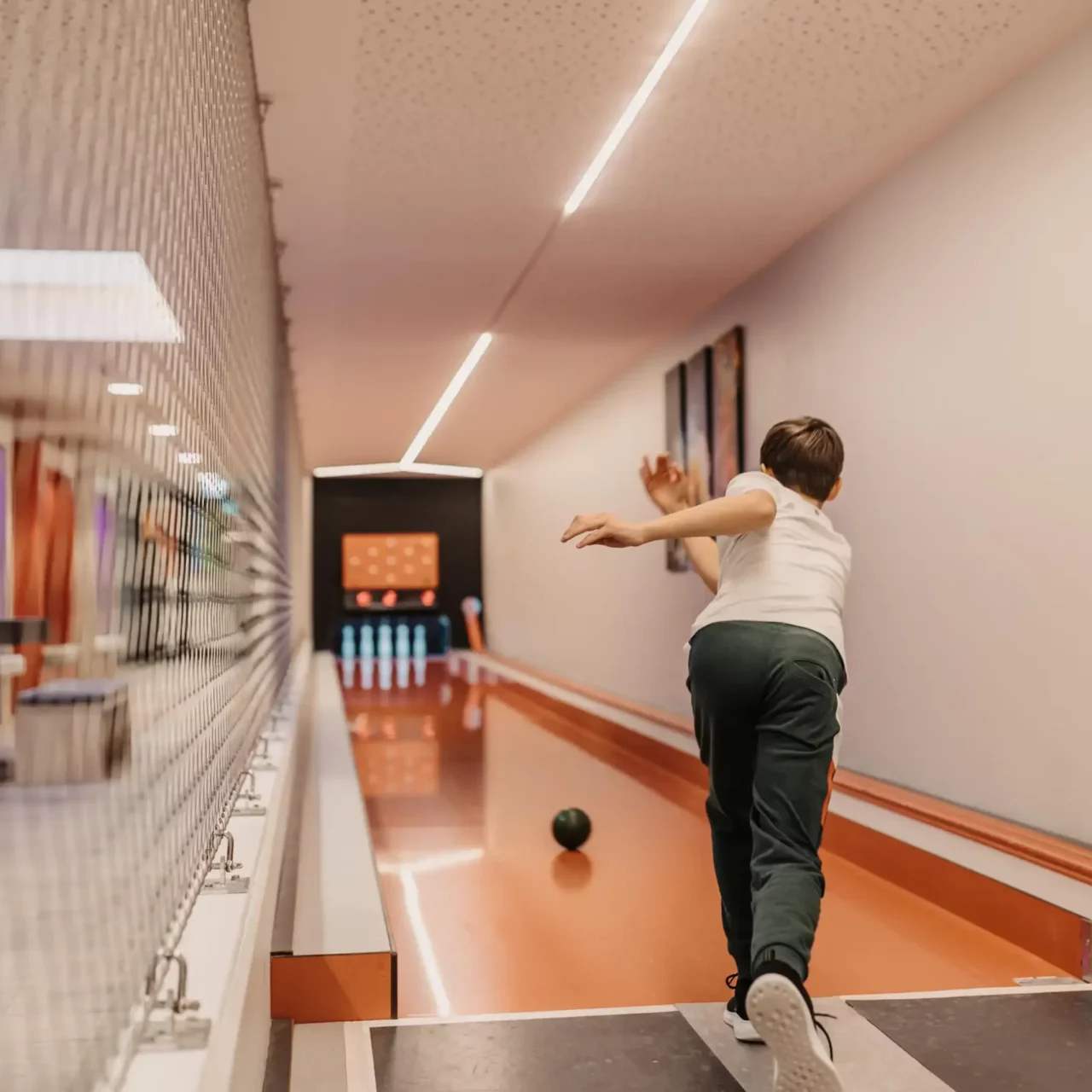 Kegelspaß mit der ganzen Familie: Gemeinsame Aktivzeit in der hauseigenen Kegelbahn des Hofgut Wagrain – für lachende Gesichter und sportliche Herausforderungen.