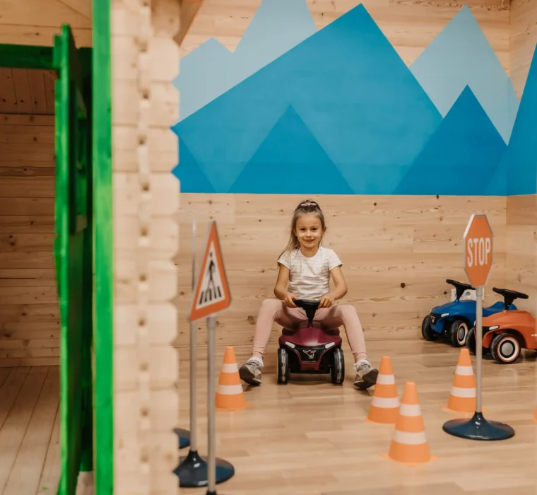 Spielerisches Fahrvergnügen im Mini Park des Hofgut Wagrain: Ein Mädchen saust mit dem Bobbycar durch einen kleinen Parcours – fröhlich, sicher und perfekt für kleine Entdecker.