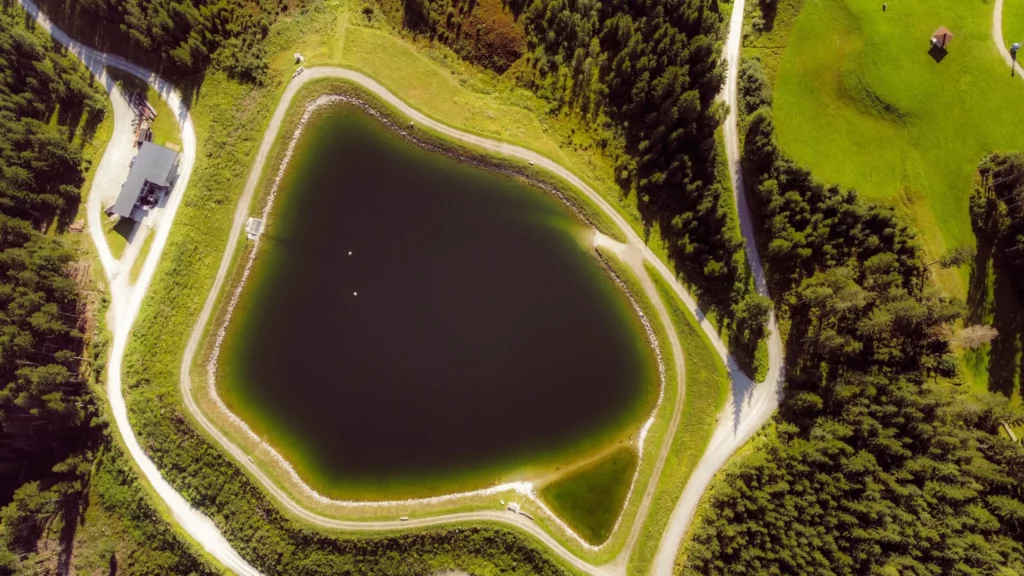 Panoramablick aus der Vogelperspektive auf den Speichersee bei Wagrain – idyllischer Ausgangspunkt für Wander- und Trailrunningtouren rund ums Hofgut.