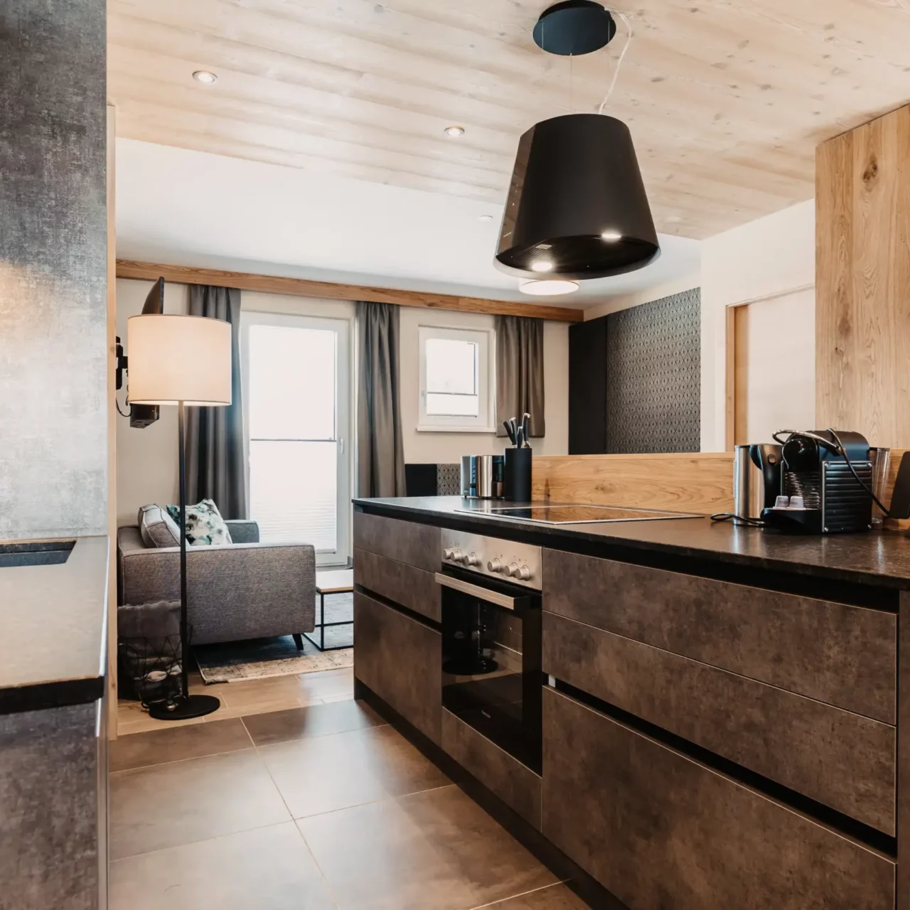 Hochwertige Küchenzeile im alpinen Industrial-Design: Die stilvolle Ausstattung des Apartments im Hofgut Wagrain macht gemeinsames Kochen zum genussvollen Erlebnis.