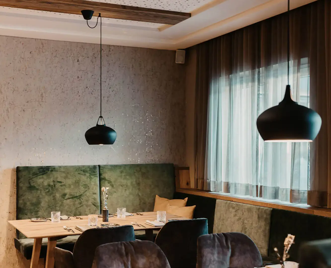 Hofgut-aparment-lifestyle-resort-wagrain-164 Cosy restaurant area at Hofgut Wagrain with stylish furnishings, soft upholstery and lovingly laid tables - an Alpine feel-good atmosphere to enjoy.