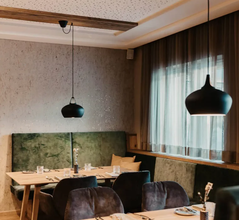 Hofgut-aparment-lifestyle-resort-wagrain-164 Gemütlicher Restaurantbereich im Hofgut Wagrain mit stilvoller Einrichtung, weichen Polstern und liebevoll gedeckten Tischen – alpine Wohlfühlatmosphäre zum Genießen.