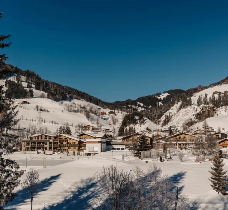 Hofgut-aparment-lifestyle-resort-wagrain-außenansicht-2 Das Hofgut Wagrain eingebettet in die verschneite Winterlandschaft – alpine Idylle und Ruhe mit Weitblick über die Berge des Salzburger Landes.