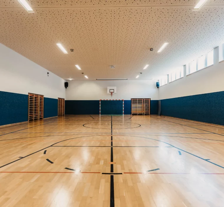 Hofgut-aparment-lifestyle-resort-wagrain-sporthalle-143 Große, helle Sporthalle im Hofgut Wagrain mit Holzfußboden, Basketballkorb und Tor – ideal für Indoor-Sport und Bewegung.