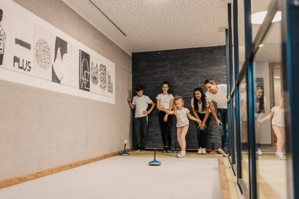 Zielsicherer Familienspaß beim Indoor-Stockschießen: Gemeinsam lachen, anfeuern und treffen – aktive Urlaubsmomente im Hofgut Wagrain.