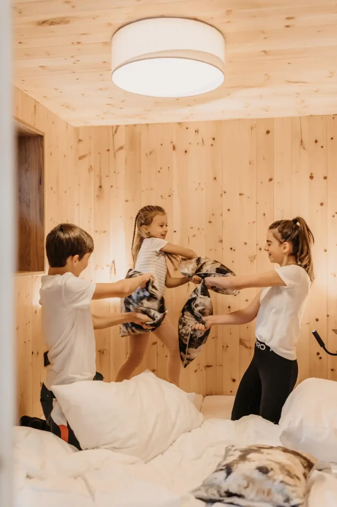 Laugh, romp, be happy: Cheerful pillow fights in the cosy children's bunks at Hofgut Wagrain - a holiday with heart and ease.