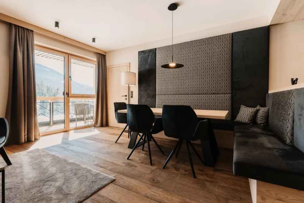 Helles Apartment im Hofgut Wagrain mit großzügiger Essecke, gemütlicher Sitzbank und Balkon mit Bergblick.