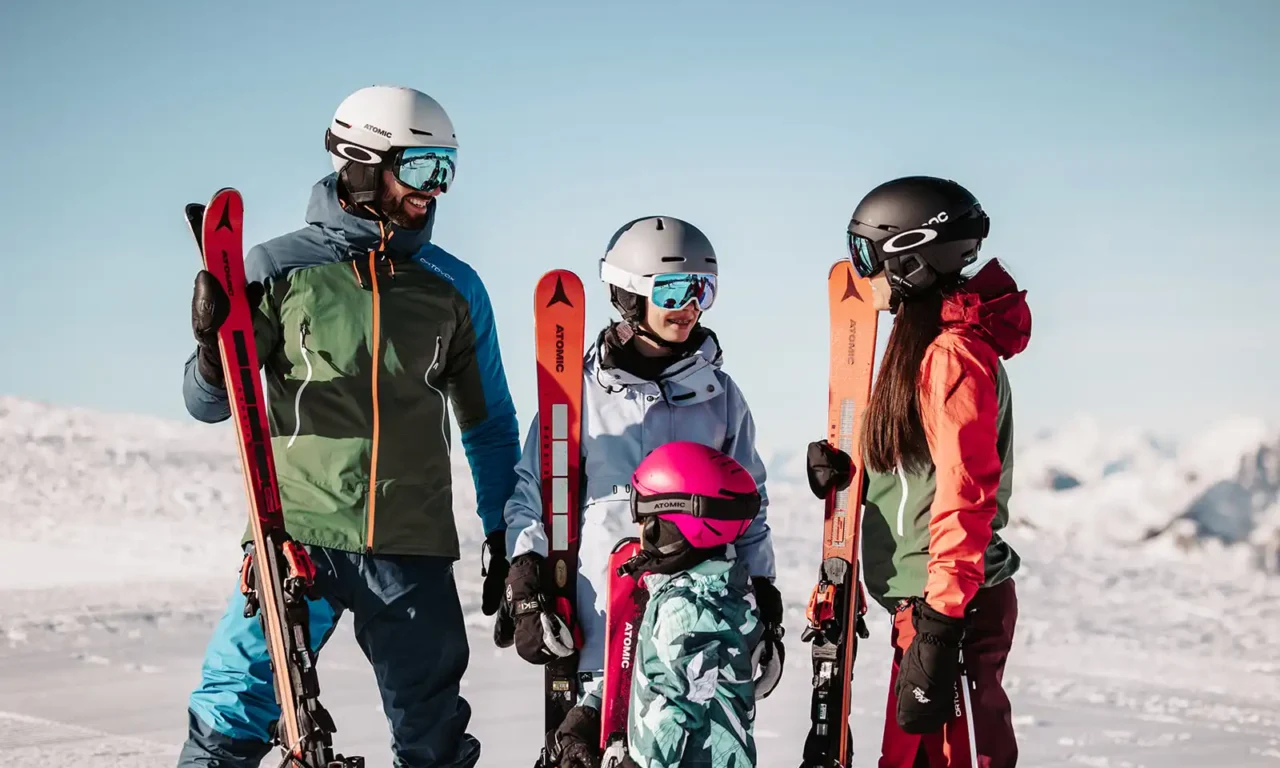 Winterglück für Groß und Klein – lachende Familie mit Skiern vor traumhafter Alpenkulisse im Hofgut Wagrain.