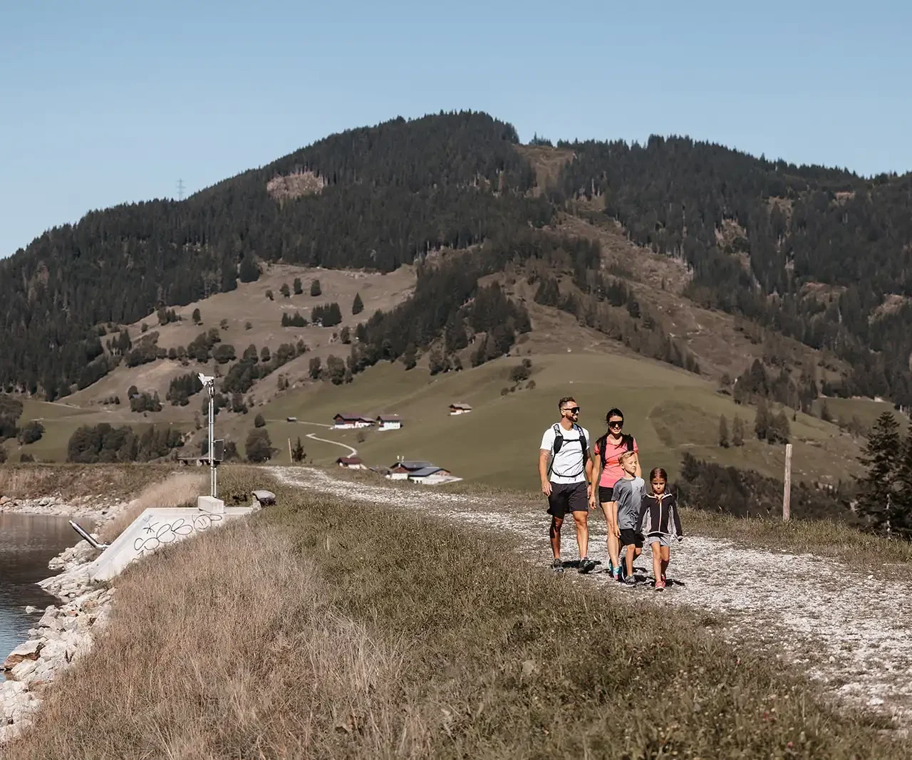 Familienwanderung auf einem sonnigen Bergweg mit Blick auf die idyllische Alpenlandschaft in Wagrain-Kleinarl.