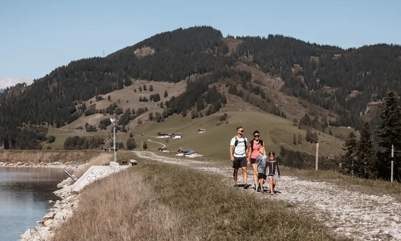 Familienwanderung auf einem sonnigen Bergweg mit Blick auf die idyllische Alpenlandschaft in Wagrain-Kleinarl.