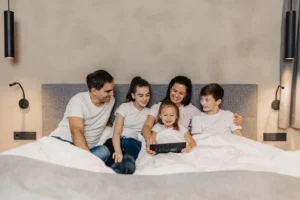Family relaxing together in bed at Hofgut Wagrain.