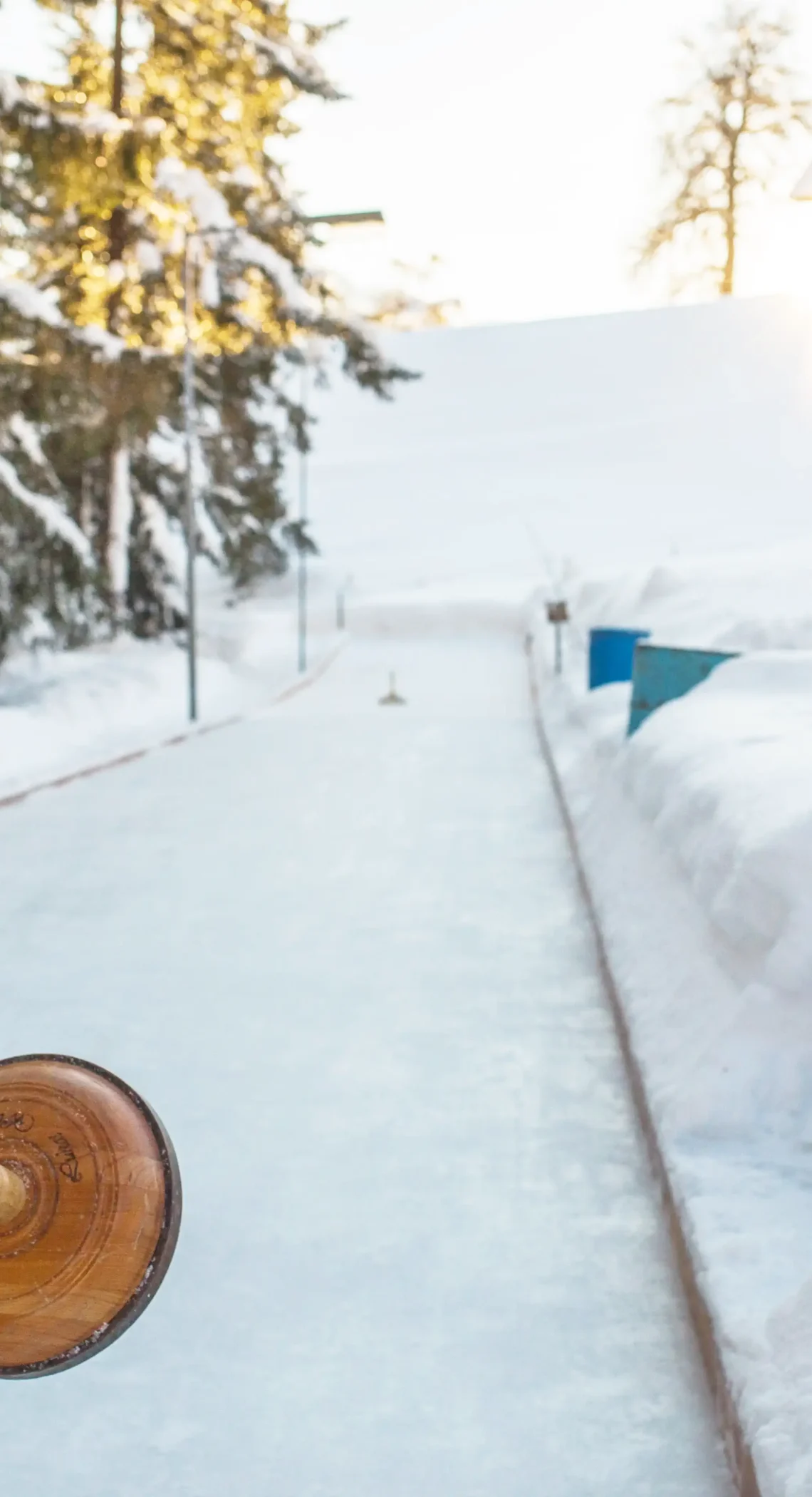 Tradition trifft Wintervergnügen – Eisstockschießen inmitten verschneiter Berglandschaft bei Sonnenuntergang.