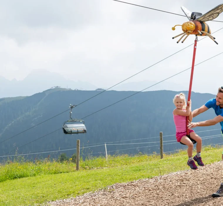 Kind fährt mit Seilbahn-Spielstation beim Weltcup der Tiere am Erlebnisberg Zauchensee