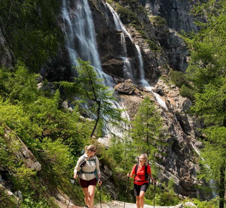 Zwei Wanderinnen auf einem Bergwanderweg beim Wasserfall in den Alpen nahe dem Tappenkarsee in Wagrain-Kleinarl.