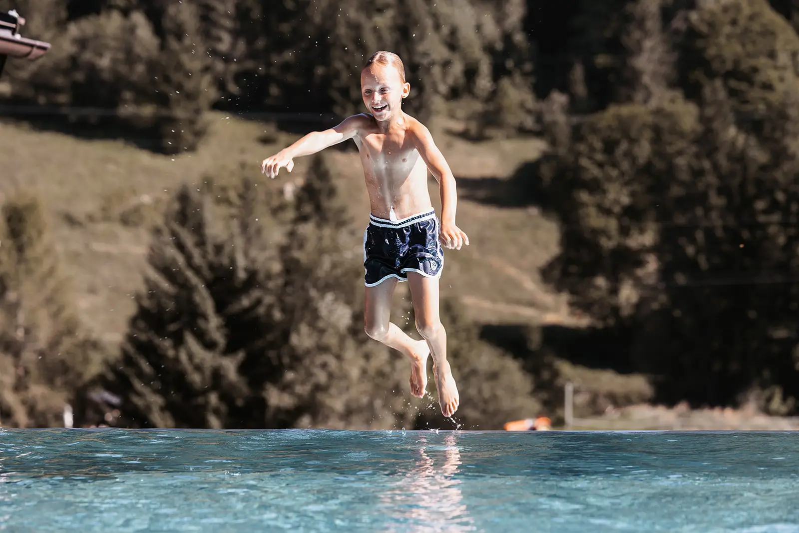 Junge springt in Hofgut Rooftop Pool.